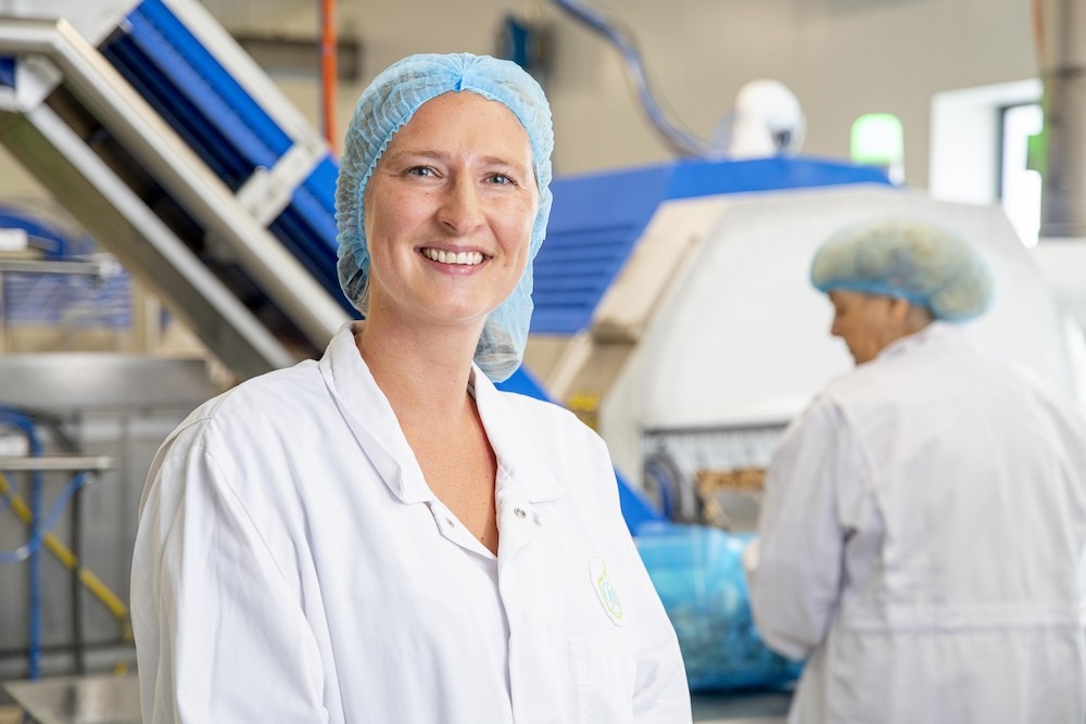 Vrouw met labjas aan in de fabriek van Ohjah