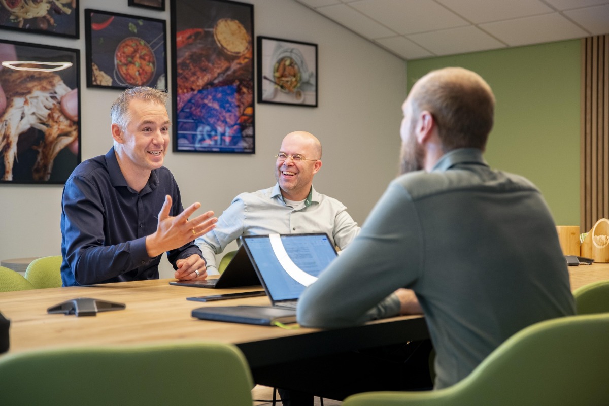 3 mannen die in een afspraak hebben. De voorste man heeft een tablet waarop notities worden geschreven